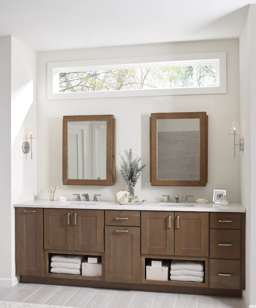 Double bathroom vanity with warm wood cabinets, white countertop and matching framed mirrors