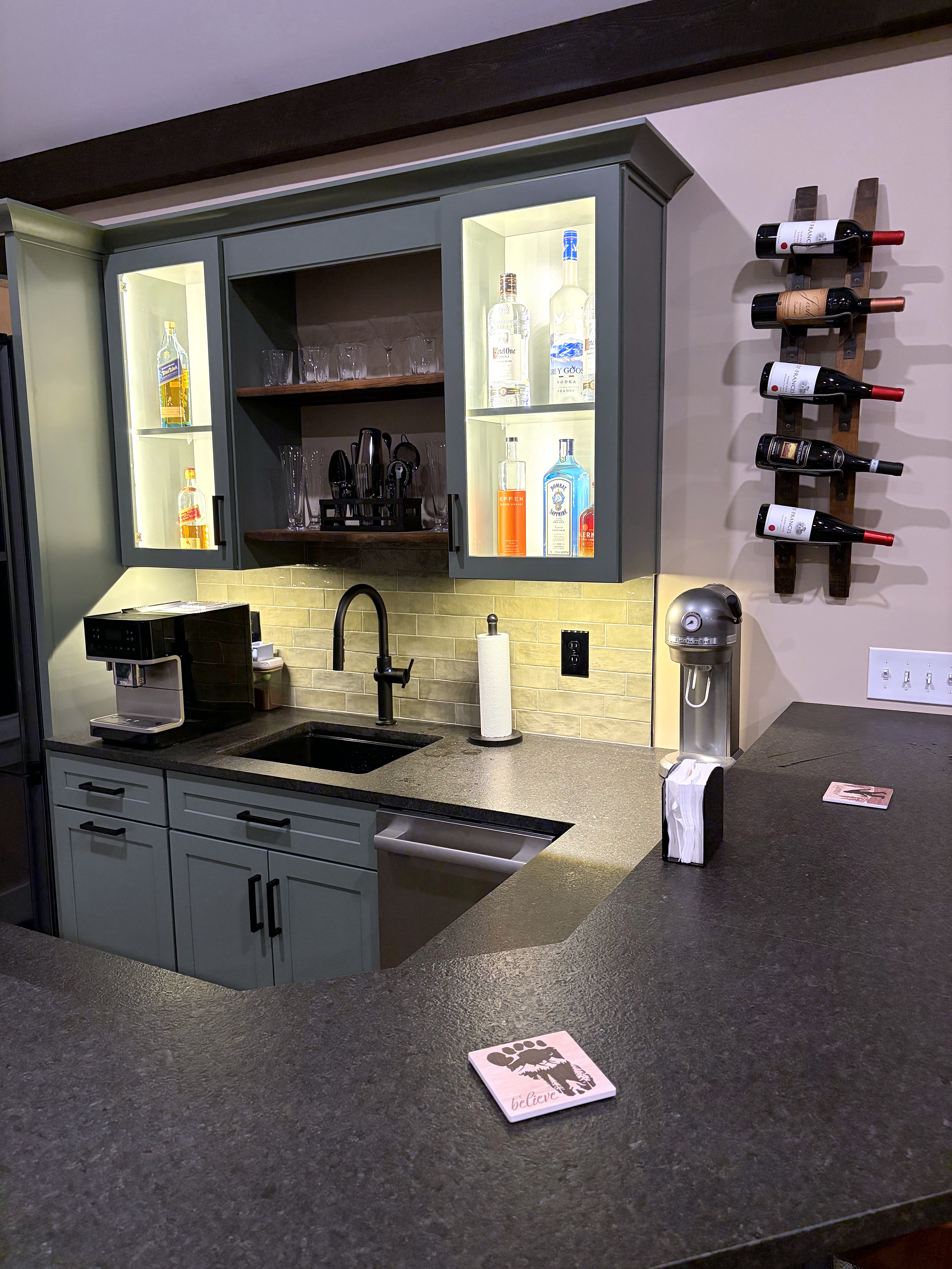 Home bar cabinetry with a sink and illuminated display shelves
