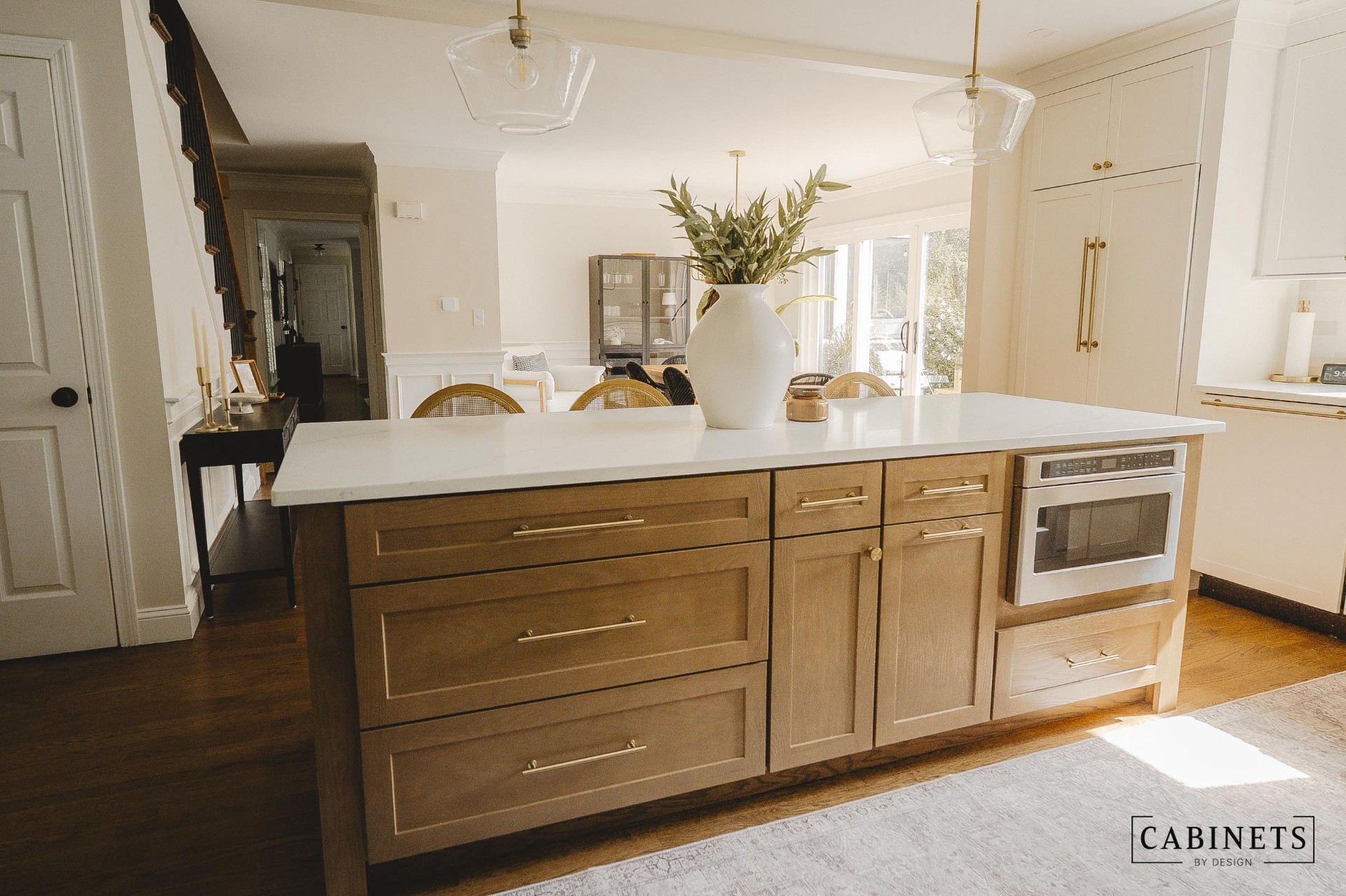 After: white oak island with deep drawer stacks, brass pulls and a built-in microwave drawer