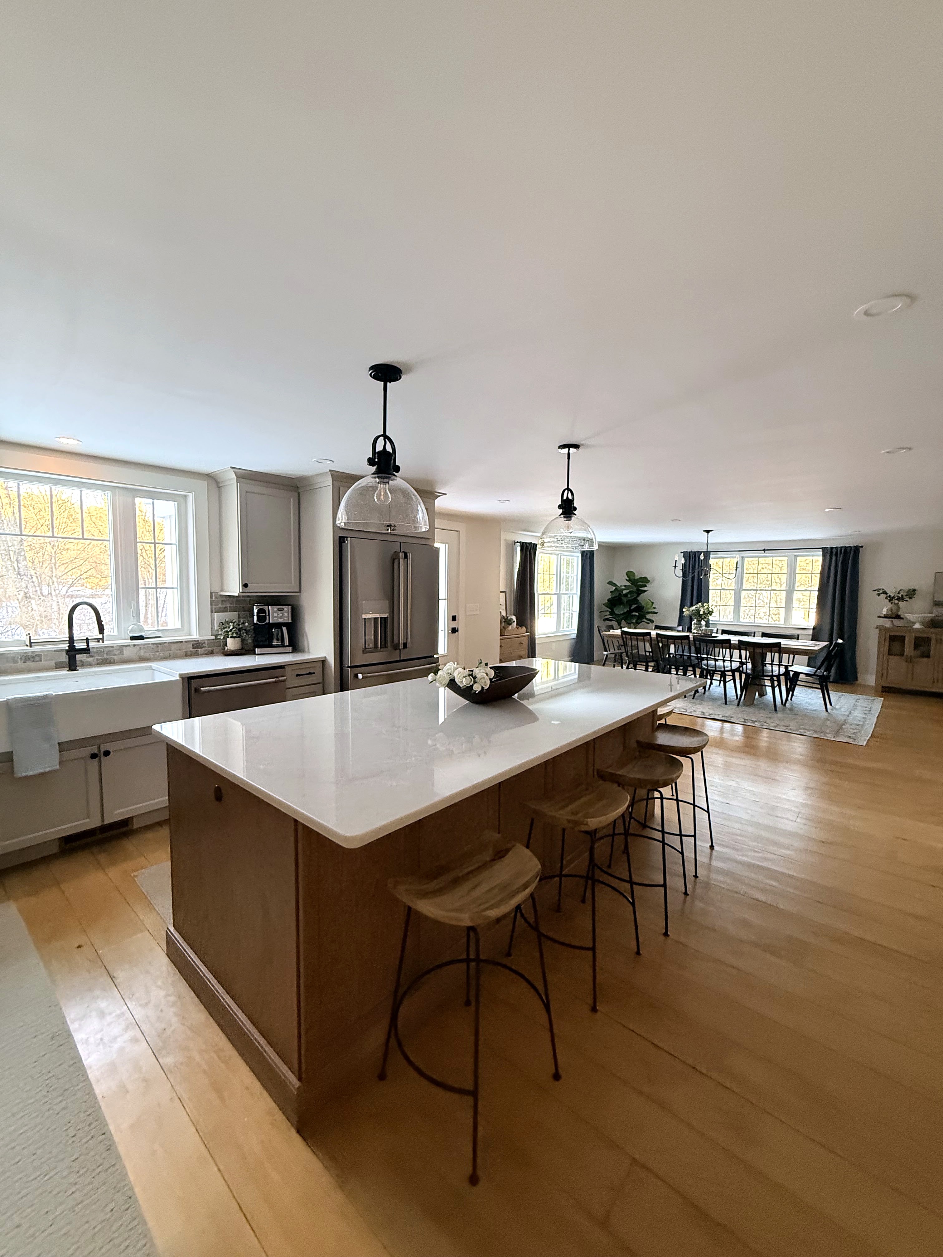 Wood kitchen island with seating and light perimeter cabinets
