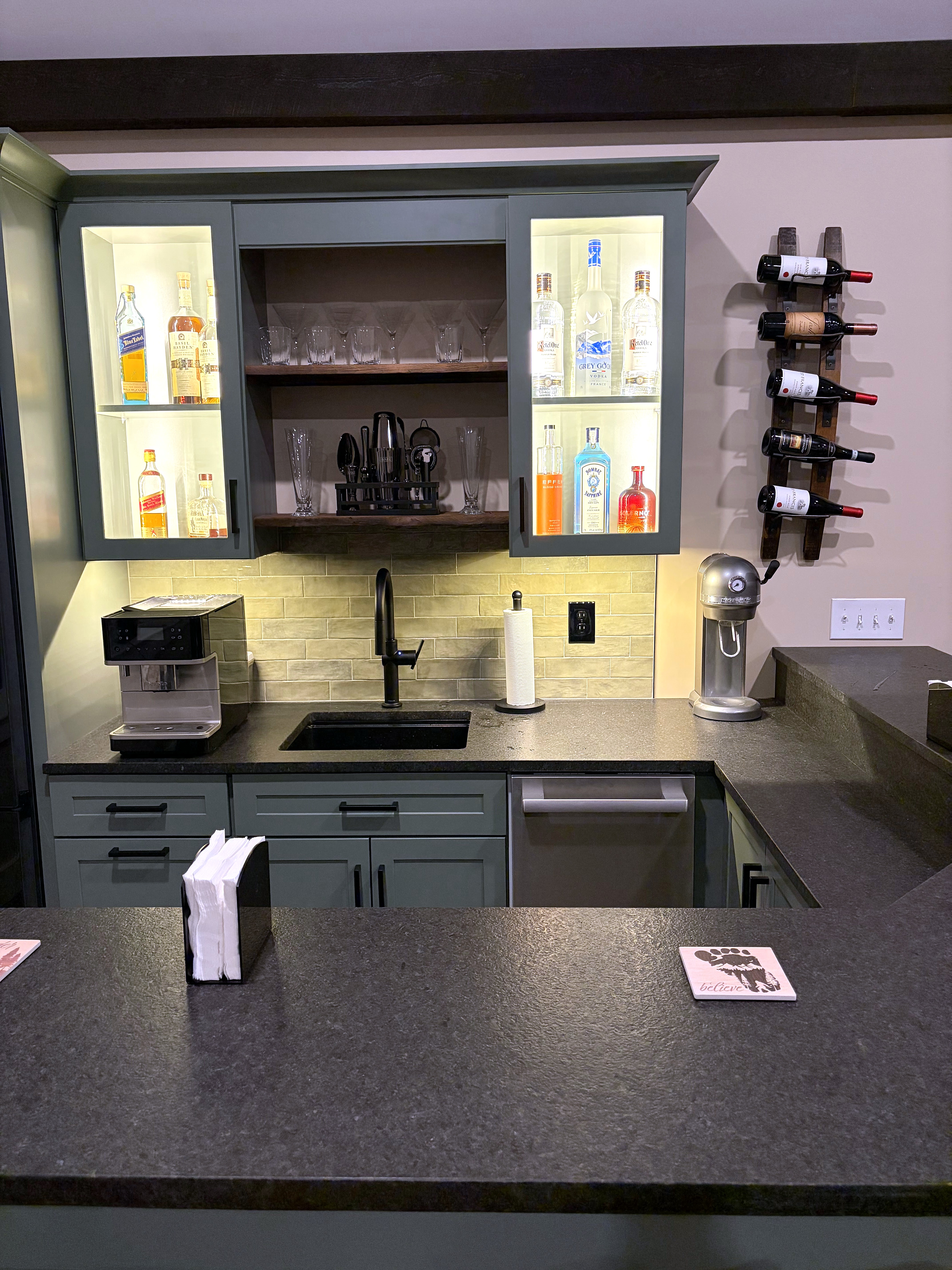 Home bar cabinets with glass-front uppers and a dark countertop