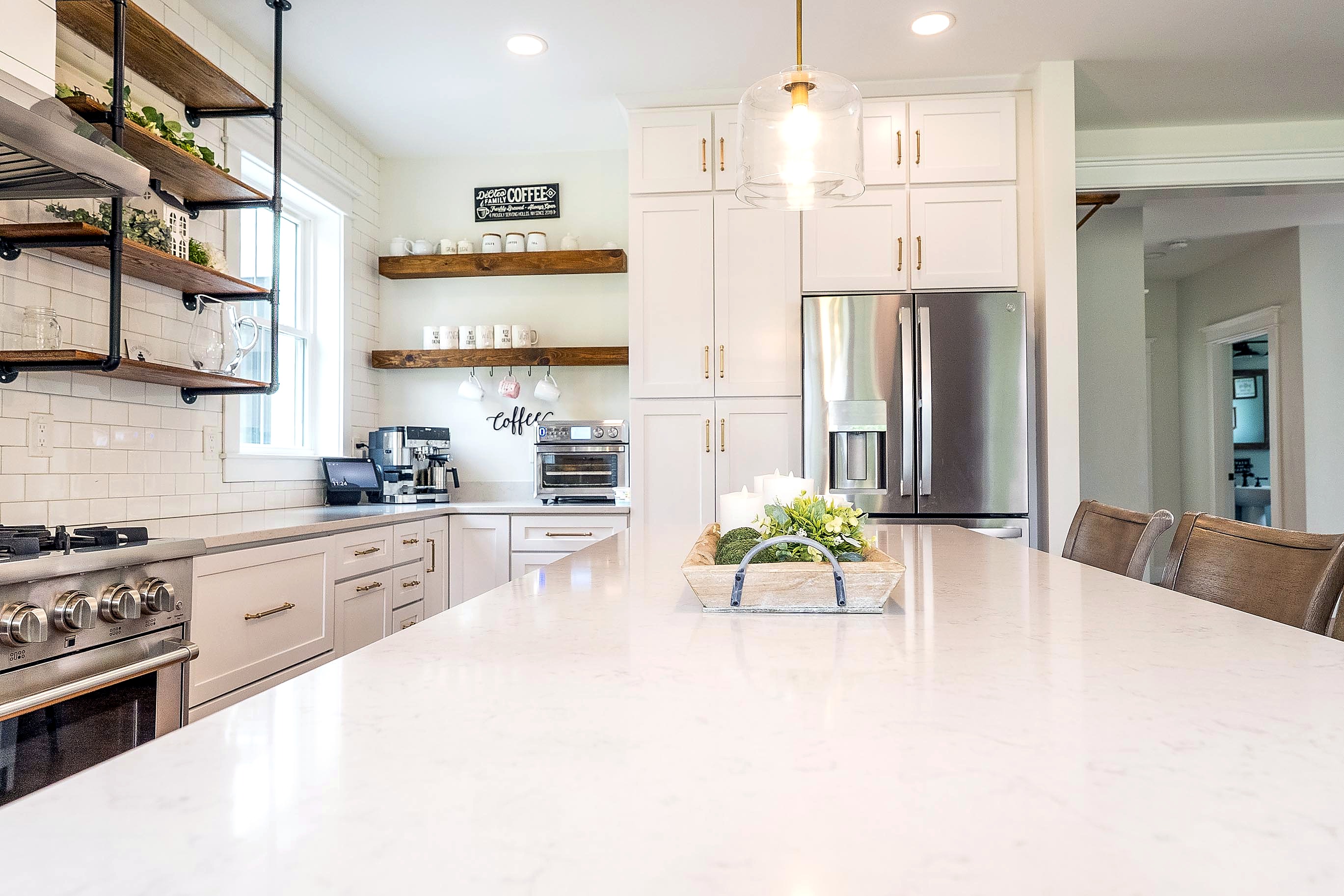 White kitchen cabinetry and open shelves beside the range