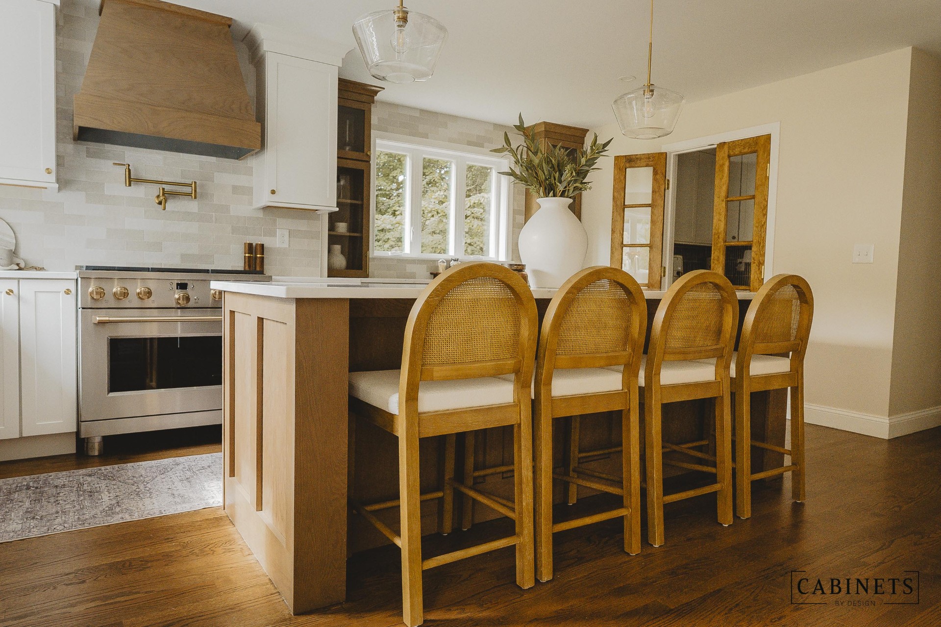 After: island seating with cane counter stools and a stained white oak island base