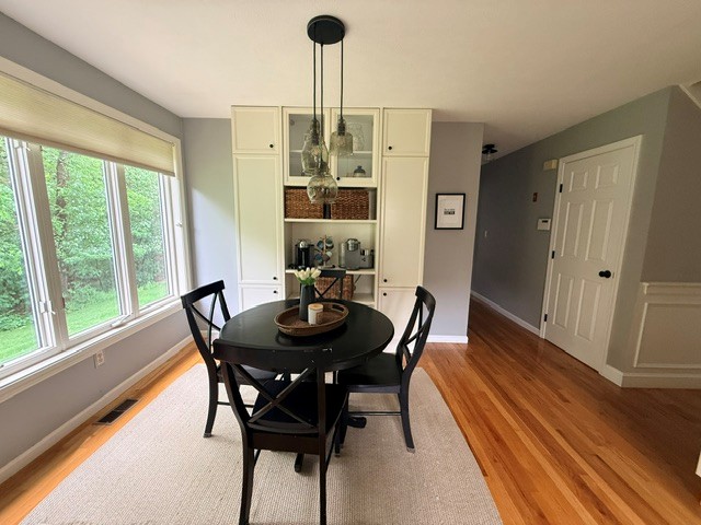 Before: dining area with a built-in cream hutch in a Hollis NH home