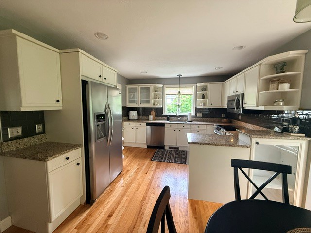Before: dated cream kitchen in Hollis NH with peninsula and dark granite counters