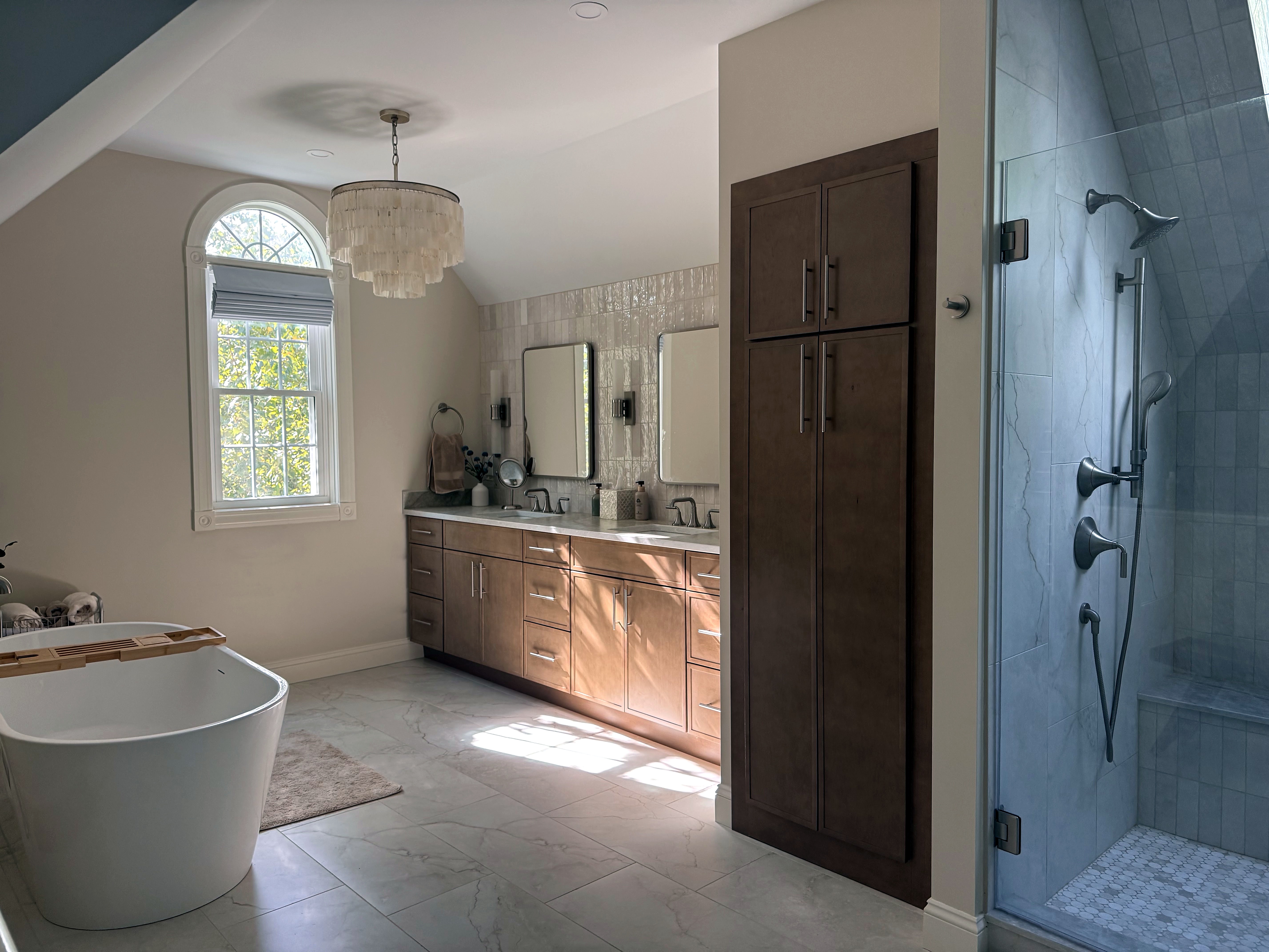 Master bathroom with a wood double vanity and tall linen cabinet